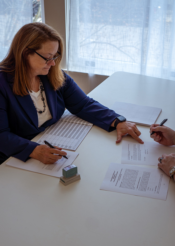 Meribeth Parker helping a client with documents